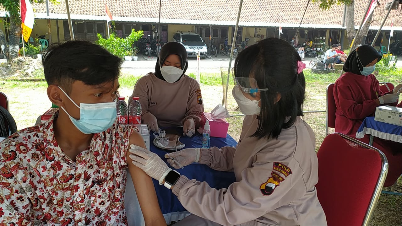 Petugas vaksinator tengah menyuntikkan vaksinasi covid-19 kepada masyarakat dalam kegiatan vaksinasi massal yang digelarBatalyon B pelopor Sat Brimob Polda Jawa Tengah di Mako Brimob Pekalongan, Sabtu 9/11/2021